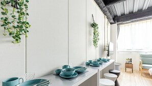 A modern kitchen with teal-colored dishware and hanging plants. - DS DOUTONBORI 2 3F (Osaka)