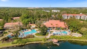 An aerial view of a resort with multiple swimming pools, a lake, and surrounding greenery. - 3 Bed/2.5 Bath Perfect Family Home Bunk Beds 3 Bedroom Townhouse by RedAwning (Kissimmee)