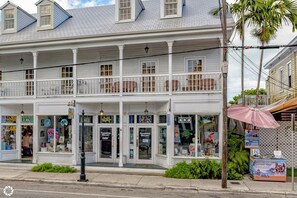 A two-story building with a balcony, storefronts, and a sign for 'Frangipani Gallery'.