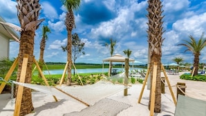 Un complexe hôtelier situé en bord de mer, avec des palmiers, un hamac et un espace piscine.