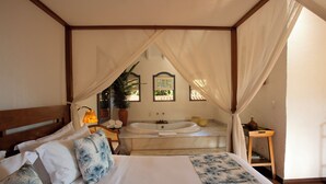 Ein Schlafzimmer mit einem großen Bett, einer Badewanne und einem Baldachin.