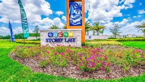 Un panneau indiquant l’emplacement de Storey Lake, orné d’une fresque aux motifs tropicaux, entouré d’un parterre de fleurs et de palmiers.