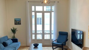 A living room with a sofa, armchair, and a coffee table. - Newly renovated apartment in Nice- with AC and 10 min walk to the beach! (Nice)