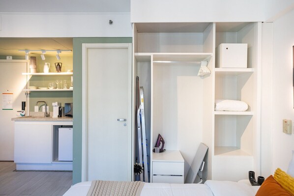 A compact hotel room with a kitchenette, a bed, a desk, and a wardrobe. - Ibirapuera by Conviva (São Paulo)
