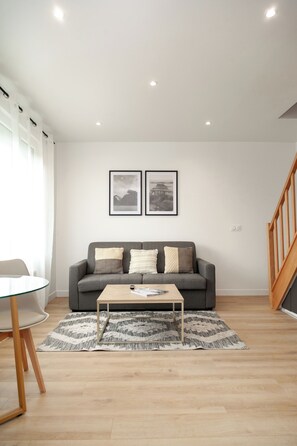 A modern living room with a grey sofa, a glass coffee table, and a patterned rug. - Duplex Three House | RER B 1 min | Netflix  (Antony)
