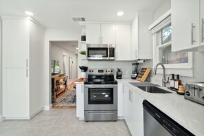 Hus - flera sängar - kök - utsikt mot trädgården (Deep in the Heart - Guest House) | Eget kök | Kaffe- och tebryggare