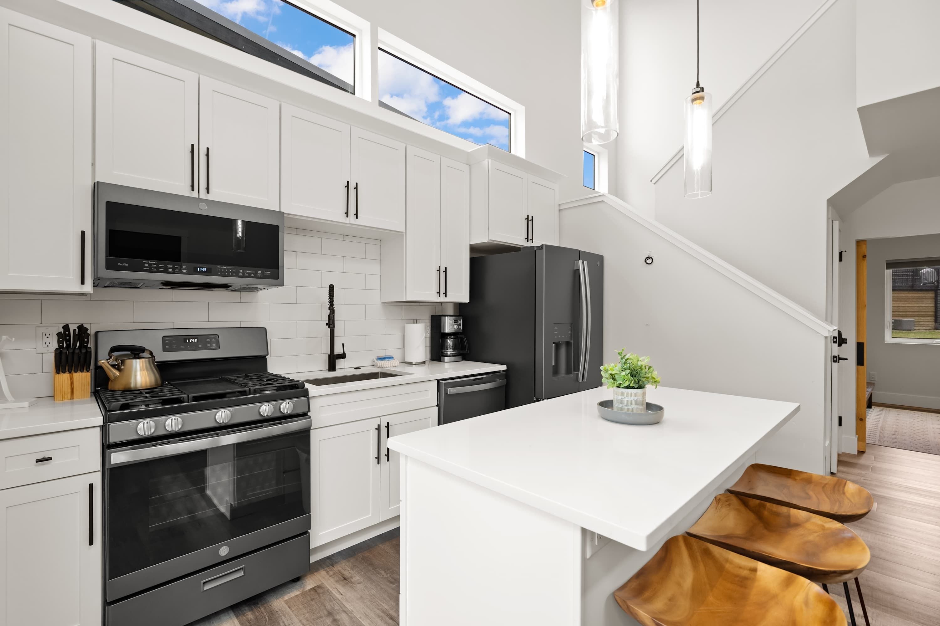 Een moderne keuken met witte kasten, roestvrijstalen apparatuur en een centraal eiland.