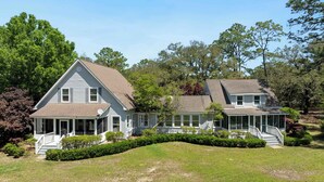 A two-story house with a porch, a covered front porch area, and a landscaped yard.