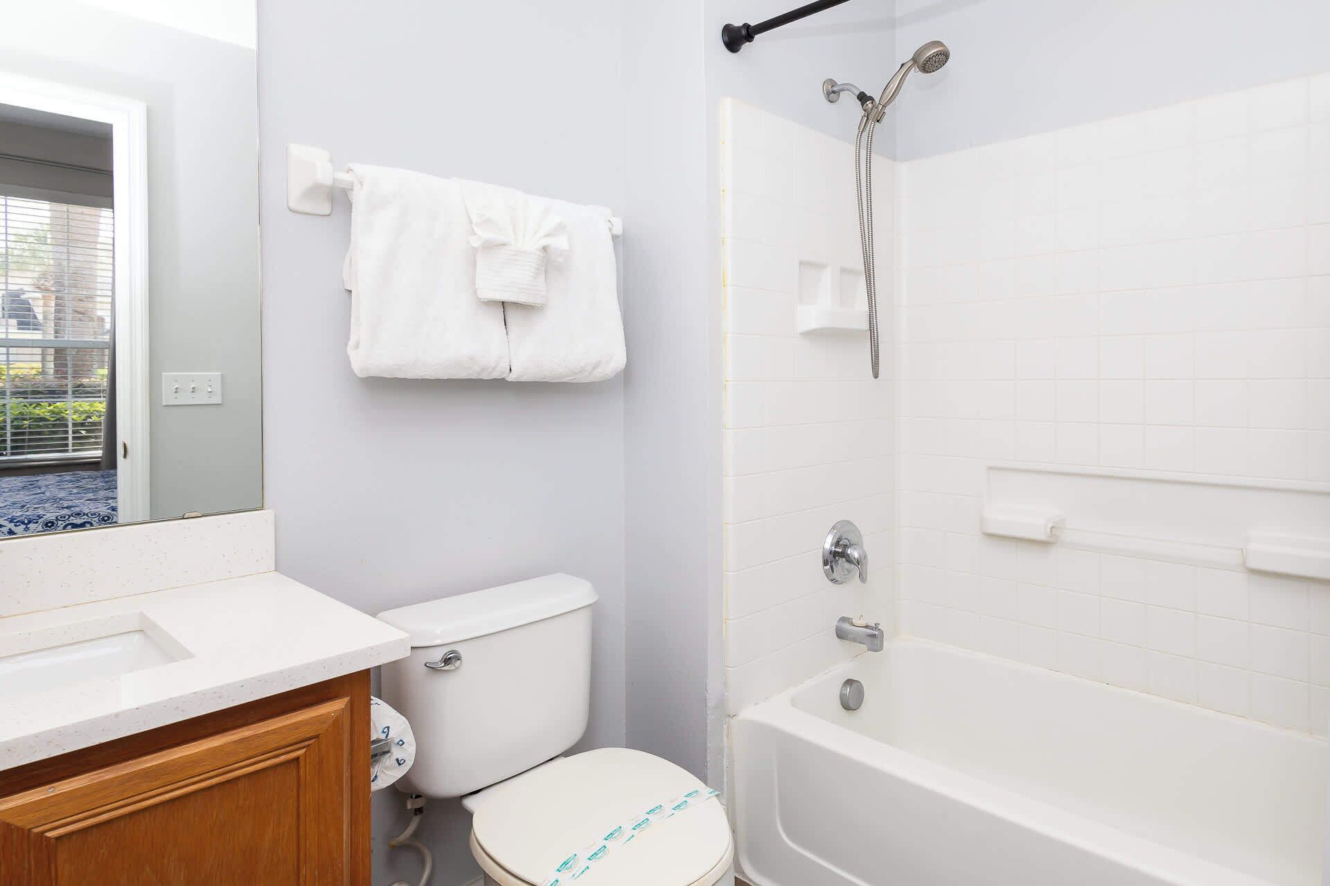 A bathroom with a toilet, sink, and bathtub.