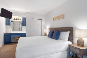 A hotel room with a large bed, a vanity with a mirror and lights, a desk, and a small stool. - Lakefront Oasis Amazing Views! (Kimberling City)