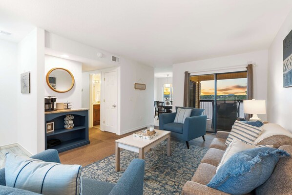 A living room with a sofa, armchairs, a coffee table, and a view of the outdoors. - Lakefront Oasis Amazing Views! (Kimberling City)