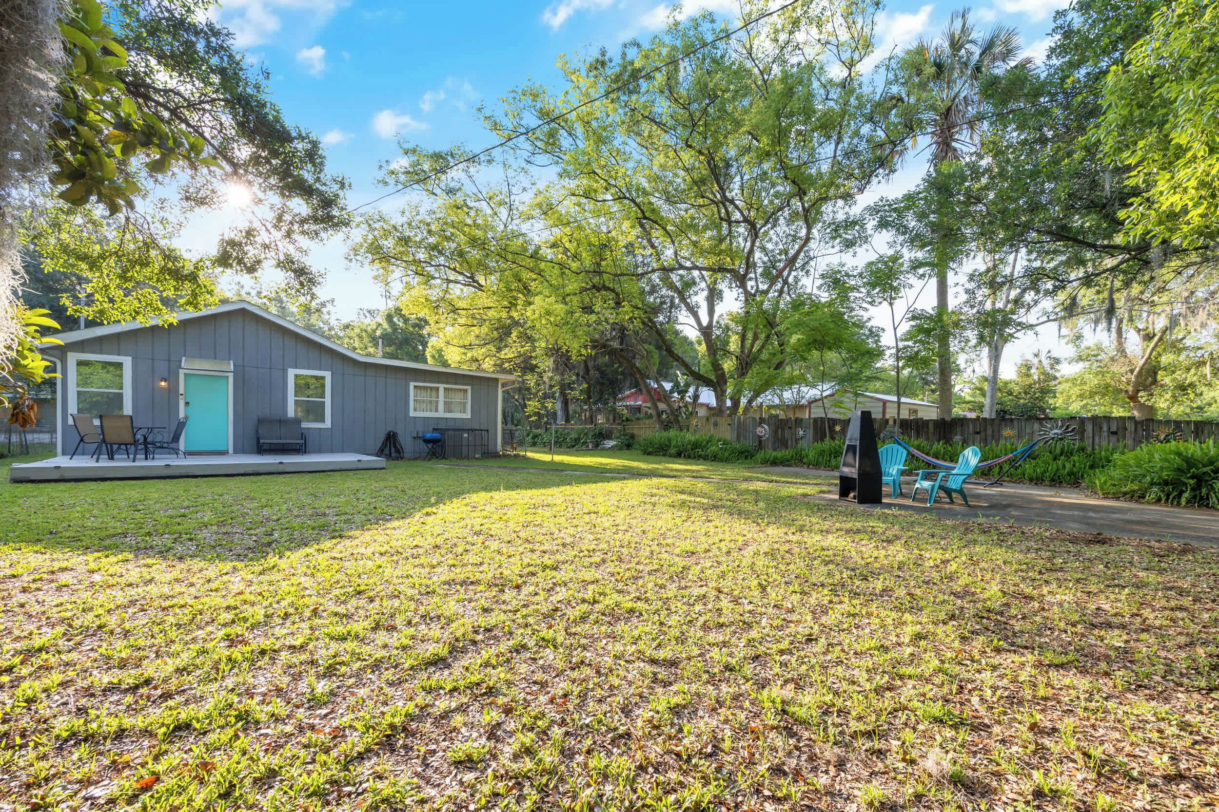 A house with a porch, a hammock, and a lawn.
