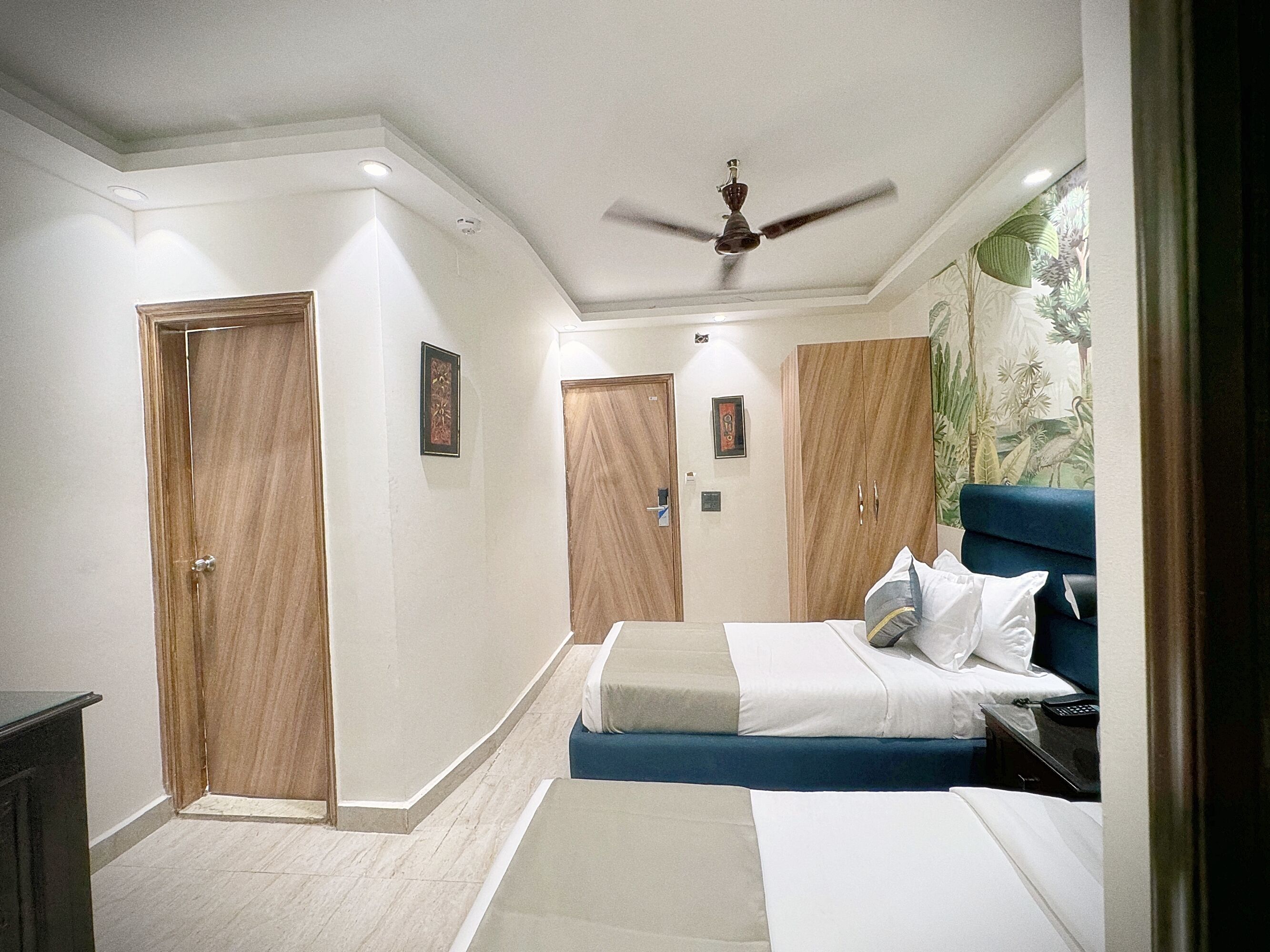 A hotel room with a bed, a desk, and a wardrobe.