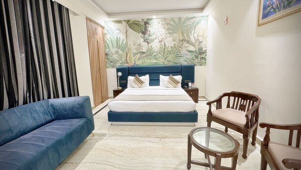 Una camera da letto con un letto, un divano blu, una sedia di legno e un tavolino.