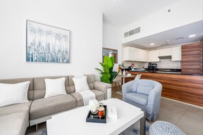Relax in a serene space with a beige sofa, white coffee table, and a light blue armchair.