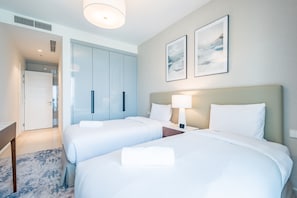 A hotel room with two beds, a desk, and a wardrobe. - Seafront 4BR Apartment with Assistant Room in The Address Fujairah Residences Block B, Fujairah (Fujairah)