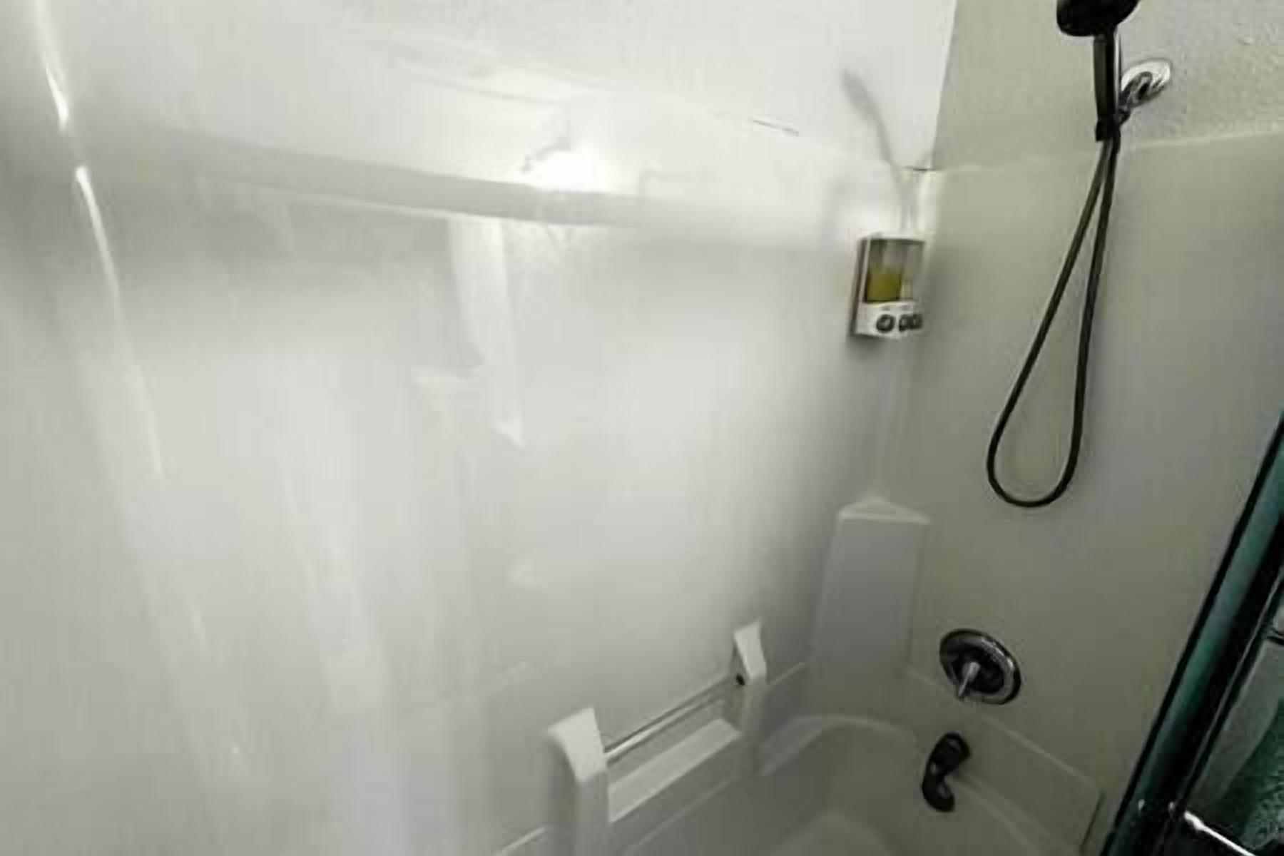 Une salle de bain avec une douche, des toilettes et un lavabo.