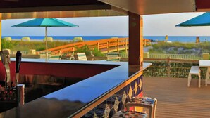 A bar area with a view of the beach and ocean.