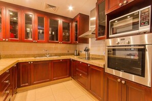 A kitchen with wooden cabinets, a stainless steel oven, and a microwave.