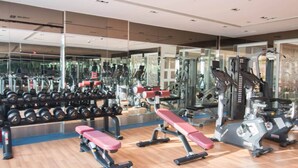 Ein Fitnessraum mit Krafttrainingsgeräten, Bänken und Kurzhanteln.