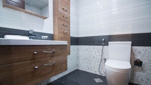 A bathroom with a wooden vanity, a toilet, and a shower.