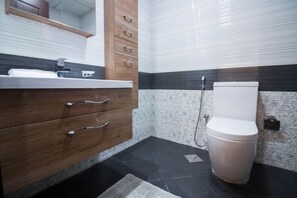 A bathroom with a wooden vanity, a toilet, and a shower.