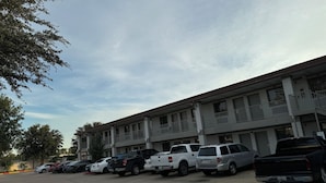 A multi-story parking garage with several vehicles parked. - LUXURY INN (Houston)