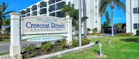 Letrero del condominio Crescent Royale con números de contacto y sitio web para alquileres.