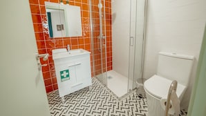 Ein Badezimmer mit Dusche, Toilette, Waschbecken und Spiegel.