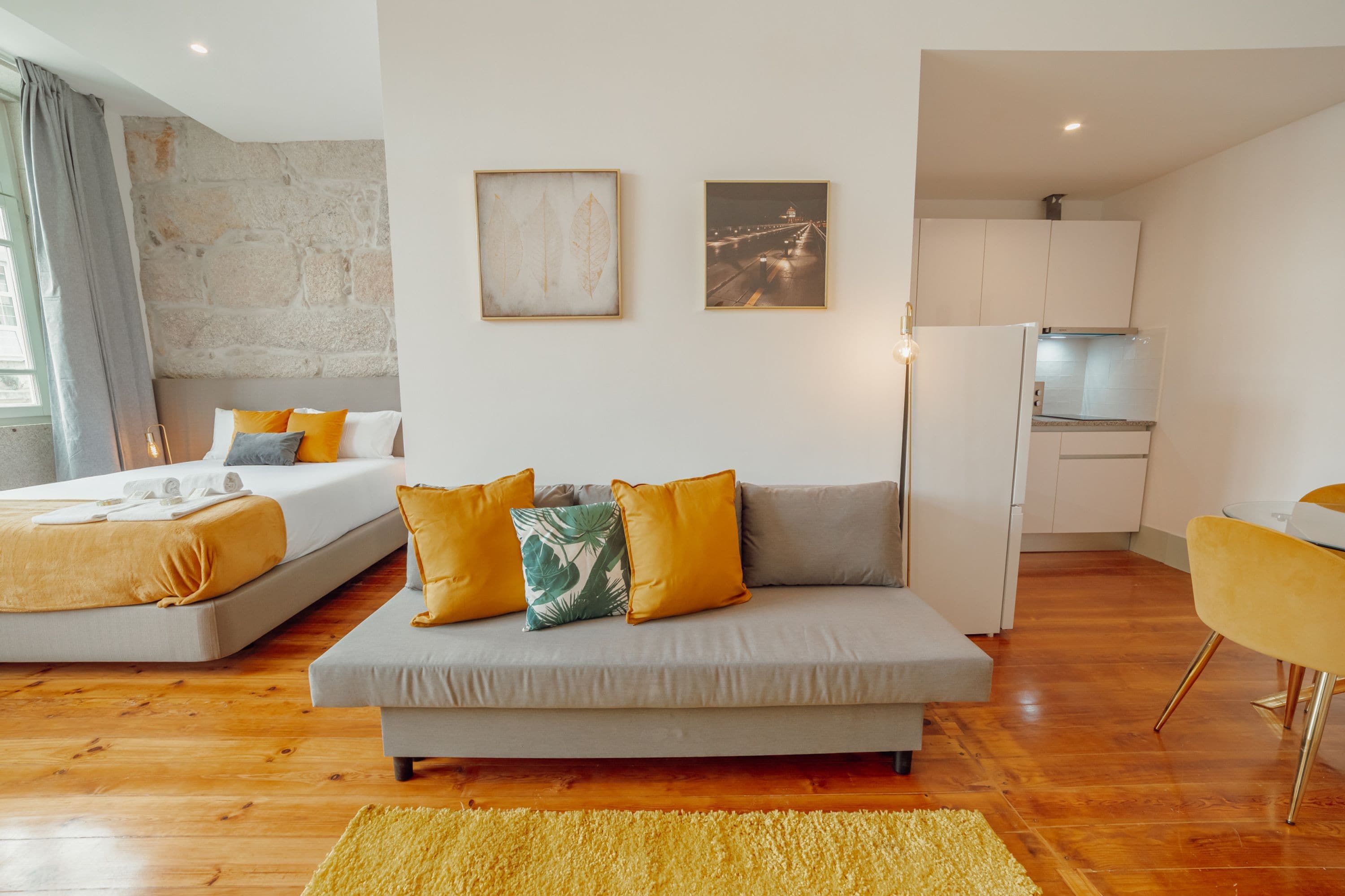 Een modern appartement met een zithoek, een bed, een keuken en een eethoek.