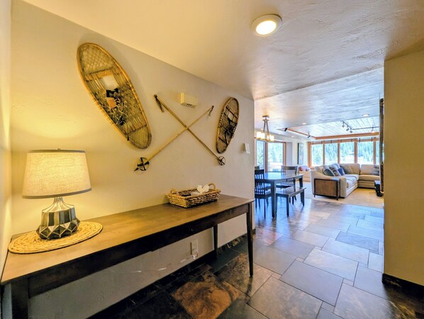 A hallway with a lamp, a woven basket, and wall-mounted items. - Keystone Lake Escape | Skate, Hot Tub + Relax (Keystone)