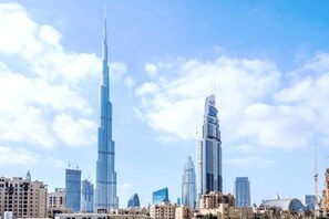A cityscape with modern skyscrapers, including a prominent tall building and a shorter, curved structure.