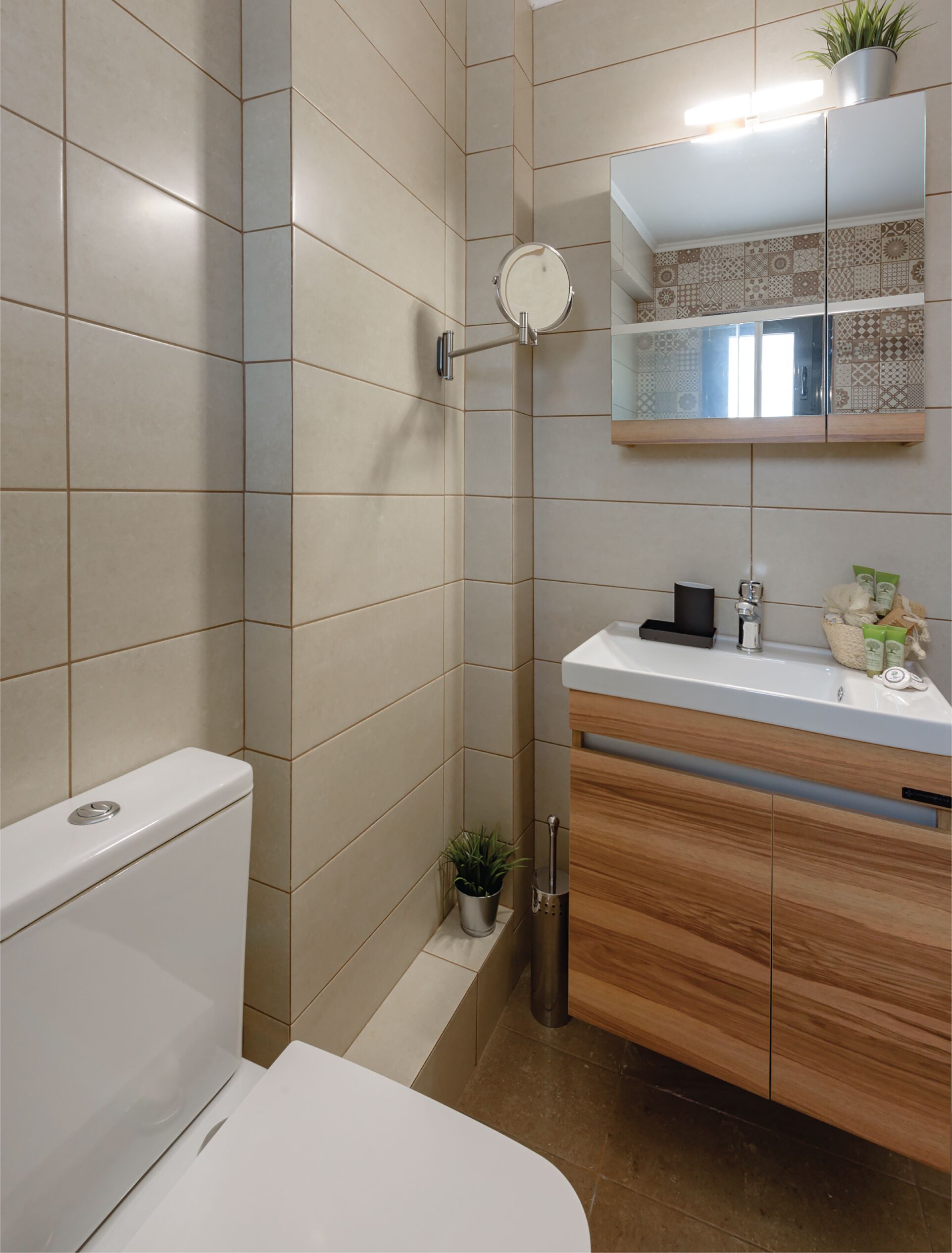 A modern bathroom with a toilet, sink, and mirror.