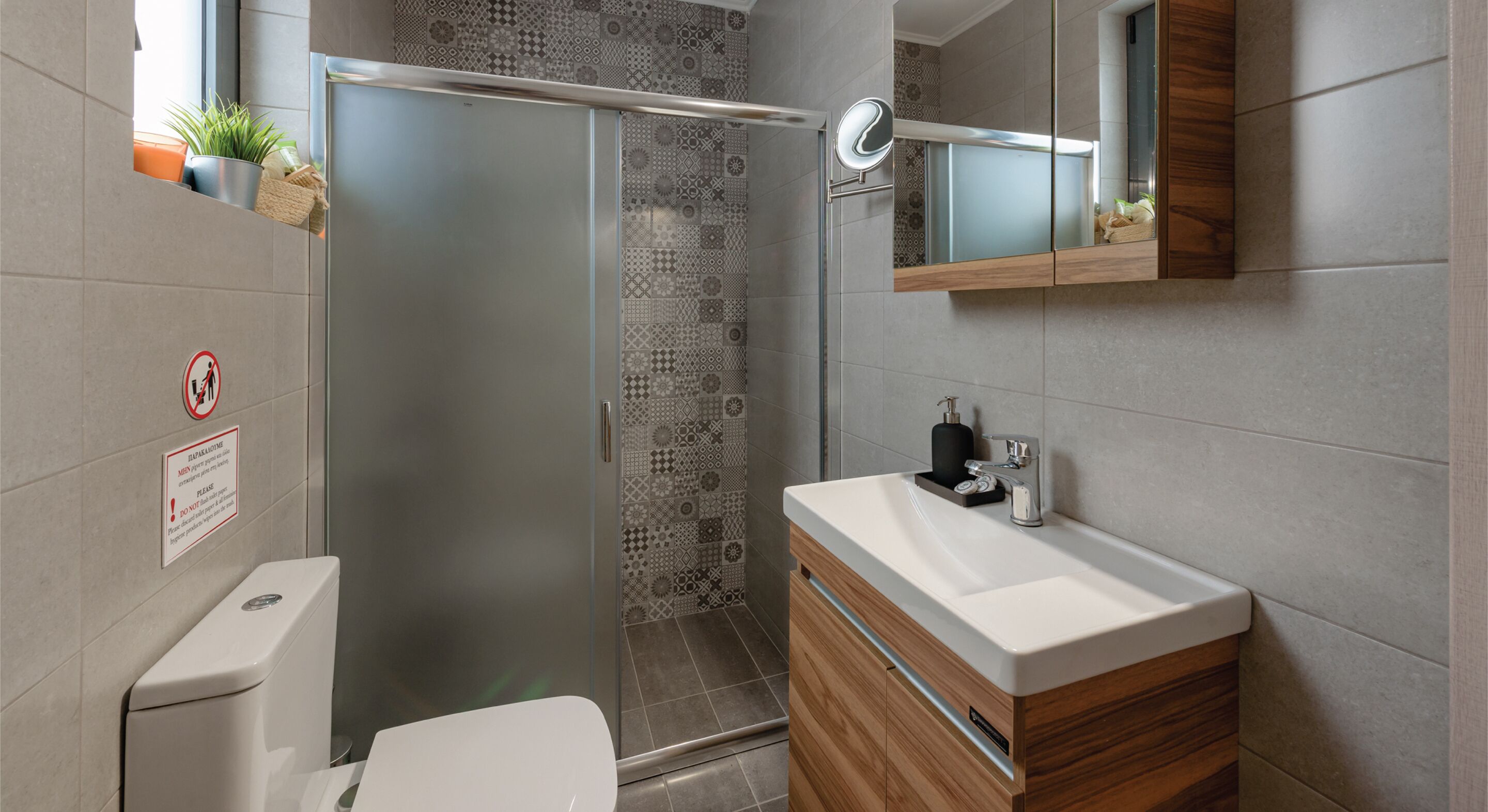A modern bathroom with a shower, toilet, and sink.