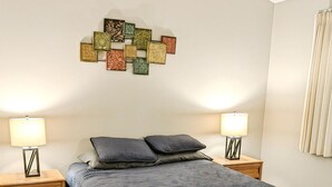 A bedroom with a bed, two nightstands, a bench, a rug, and a wall decoration. - 2 Br 2 b Condo at Unv of Notre Dame Short and Long Term Stays Welcome ND Football A5 (South Bend)