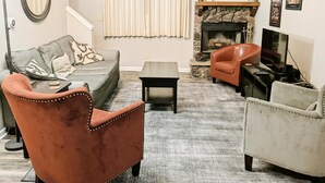 A living room with a sofa, two armchairs, a coffee table, a fireplace, and a television. - 2 Br 2 b Condo at Unv of Notre Dame Short and Long Term Stays Welcome ND Football A5 (South Bend)