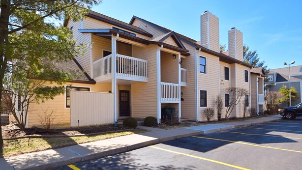 A multi-story apartment building with balconies, a parking lot, and a clear sky. - 2 Br 2 b Condo at Unv of Notre Dame Short and Long Term Stays Welcome ND Football A5 (South Bend)
