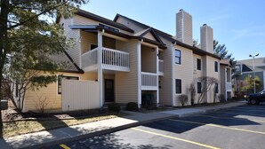 A multi-story residential building with a central courtyard, balconies, and a parking lot. - Condo at the University of Notre Dame D3 (South Bend)