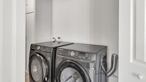 Une buanderie équipée de deux machines à laver à chargement frontal et d’un sèche-linge.