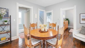 A dining room with a round wooden table, six chairs, and a bookshelf. - 3 Bedroom 2 Bath Home Near Notre Dame 123nd (South Bend)