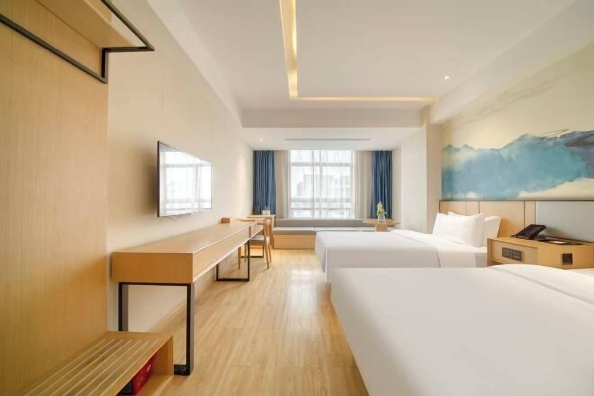 A hotel room with a bed, a desk, and a TV.