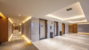 A modern hotel lobby with a long corridor, marble flooring, and a clean, minimalist design. - Greentree Eastern Hotel (Zhongshan West Road, Xiuzhou District, Jiaxing) (Jiaxing)