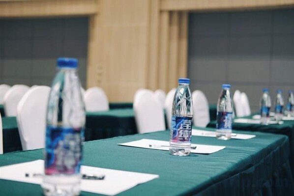 A conference room with tables set up for a meeting, each with a water bottle and a name tag.