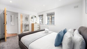 A bedroom with a bed, a dresser, a mirror, and a window. - Cozy private 1-bedroom apartment in Hoxton (Greater London)