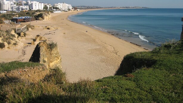 Une plage côtière avec des bâtiments en arrière-plan.