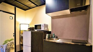 A compact kitchen with a microwave, a small refrigerator, and a sink.