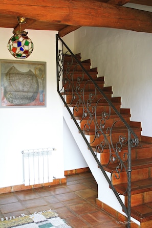 A wooden staircase with ornate metal railings, a mosaic light fixture, and a framed artwork on the wall. - Country Rental Home Genalguacil Jubrique. Hiking, Biking, Nature, White Villages (Jubrique)