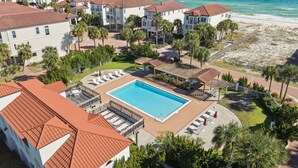 Ein Resort mit Pool, Zugang zum Strand und mehreren Gebäuden mit roten Ziegeldächern.