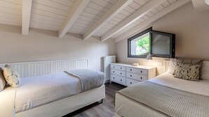 Un dormitorio con dos camas, un aparador, una ventana y un televisor.