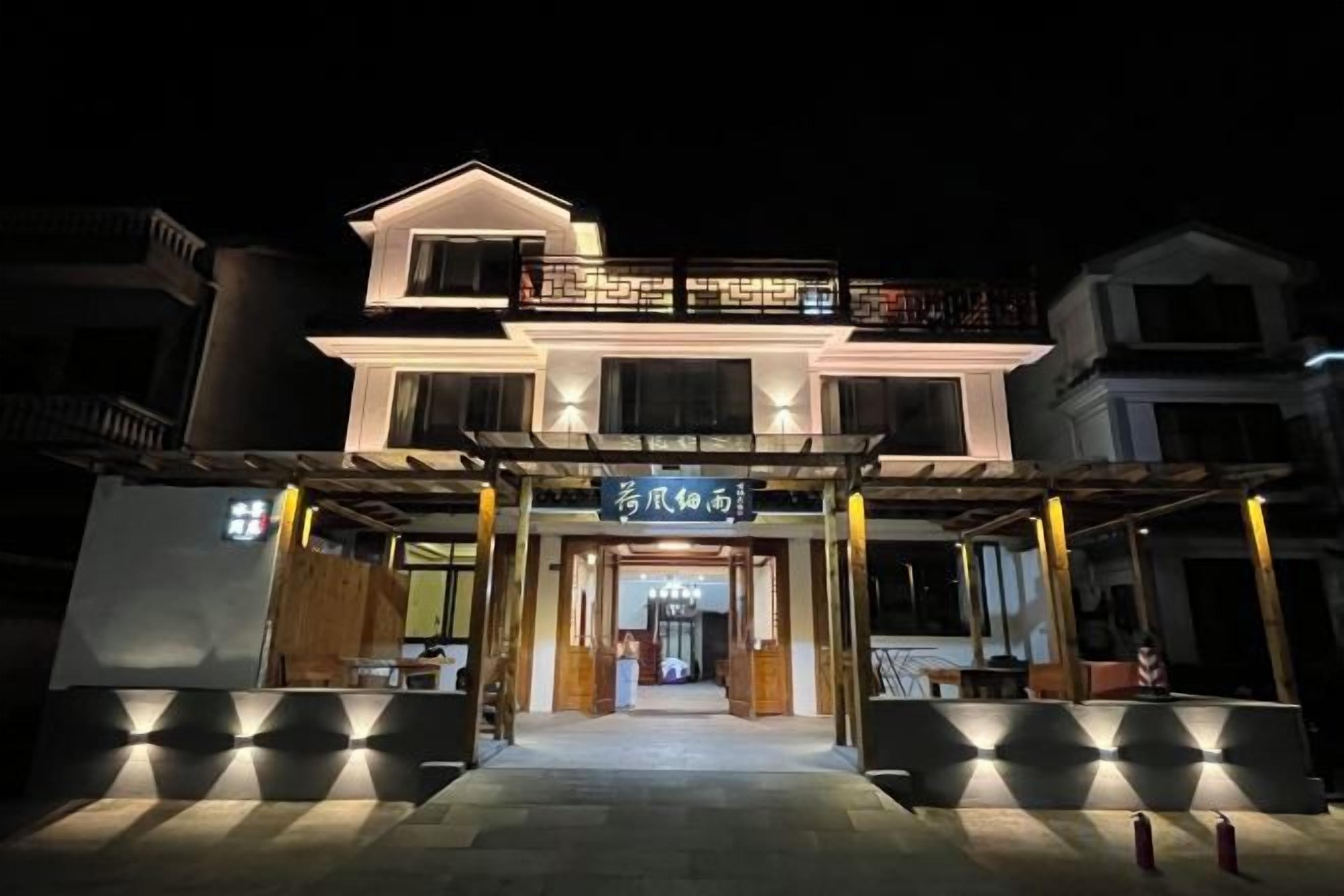 A two-story building with a balcony and a sign above the entrance.